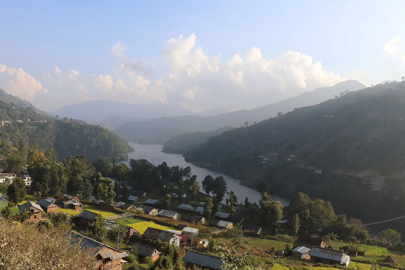 Markhu village beside the Indra Sarowar reservoir with hills behind.