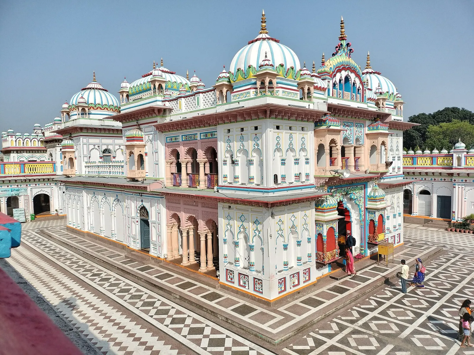 The white, ornately decorated Janaki Mandir with domed towers and a patterned marble courtyard