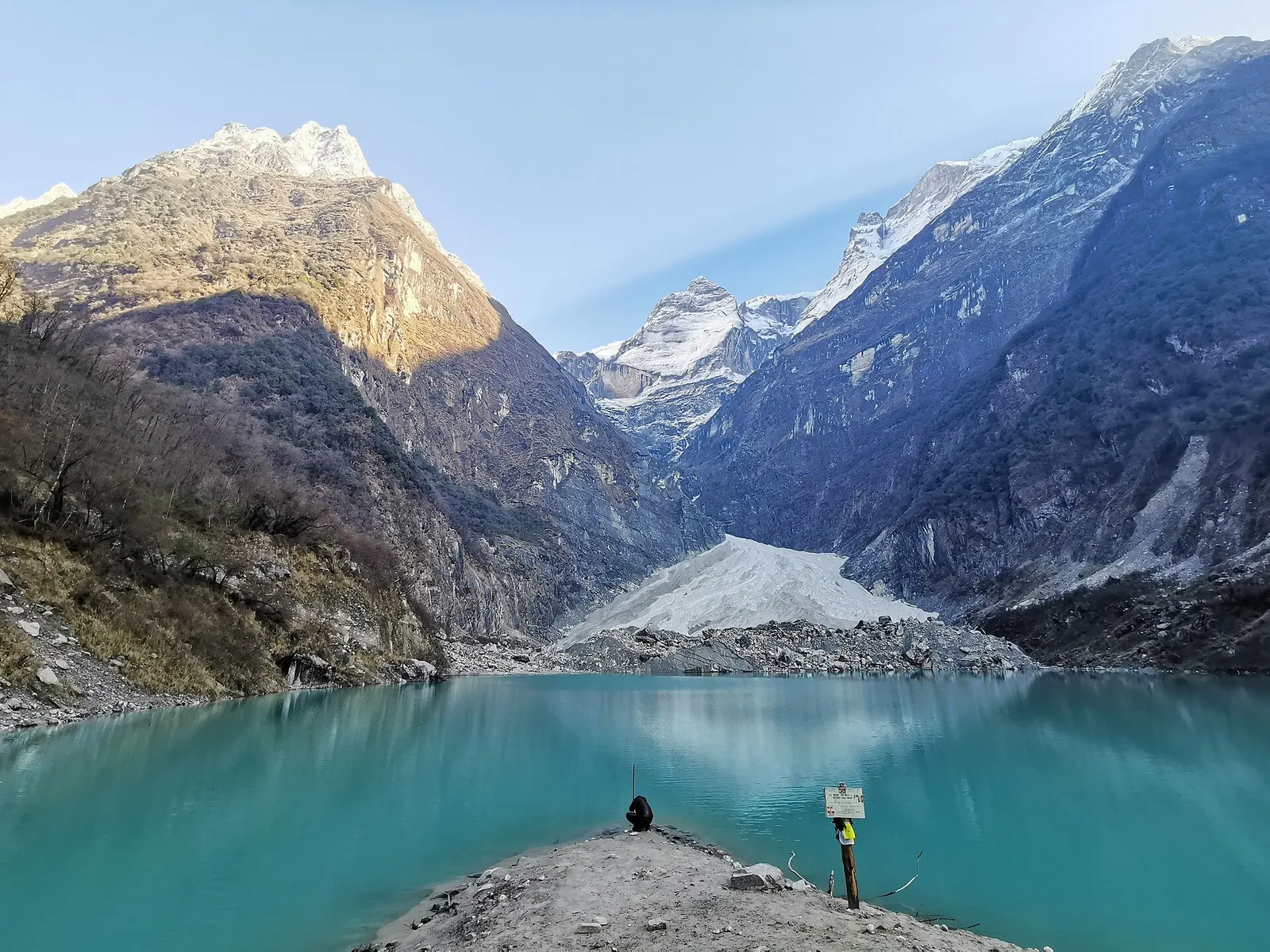 Kapuche glacier lake lying in a rocky basin beneath steep snow and ice slopes.