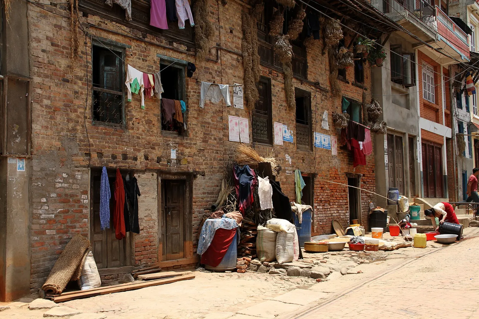 A traditional brick house with carved wooden windows in Khokana.