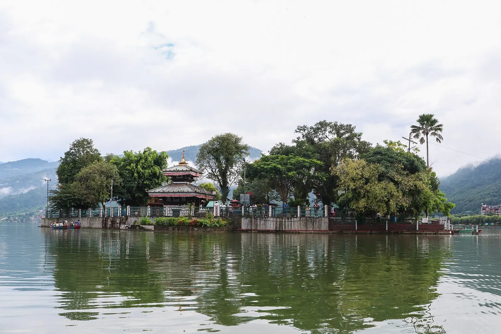 The small wooded island of Tal Barahi with its pagoda-roofed temple reflected in the calm water of Phewa Lake.