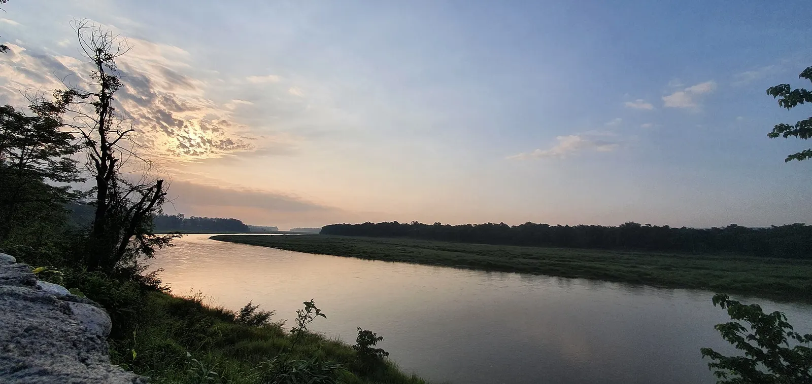 The calm Rapti River at sunrise, with forest lining the far bank of Chitwan National Park
