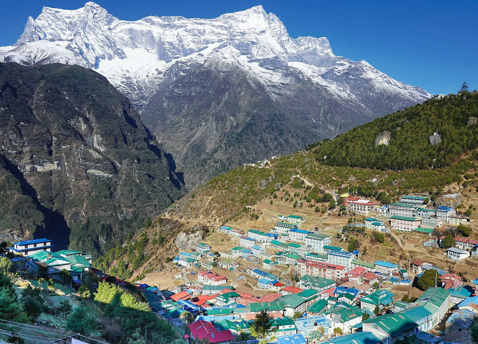 Namche Bazaar's colourful rooftops in a horseshoe-shaped hillside bowl beneath the snow-covered Kongde Ri